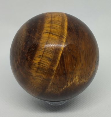 Sphère en pierre de tigre, rayures dorées et brunes, polie et brillante.